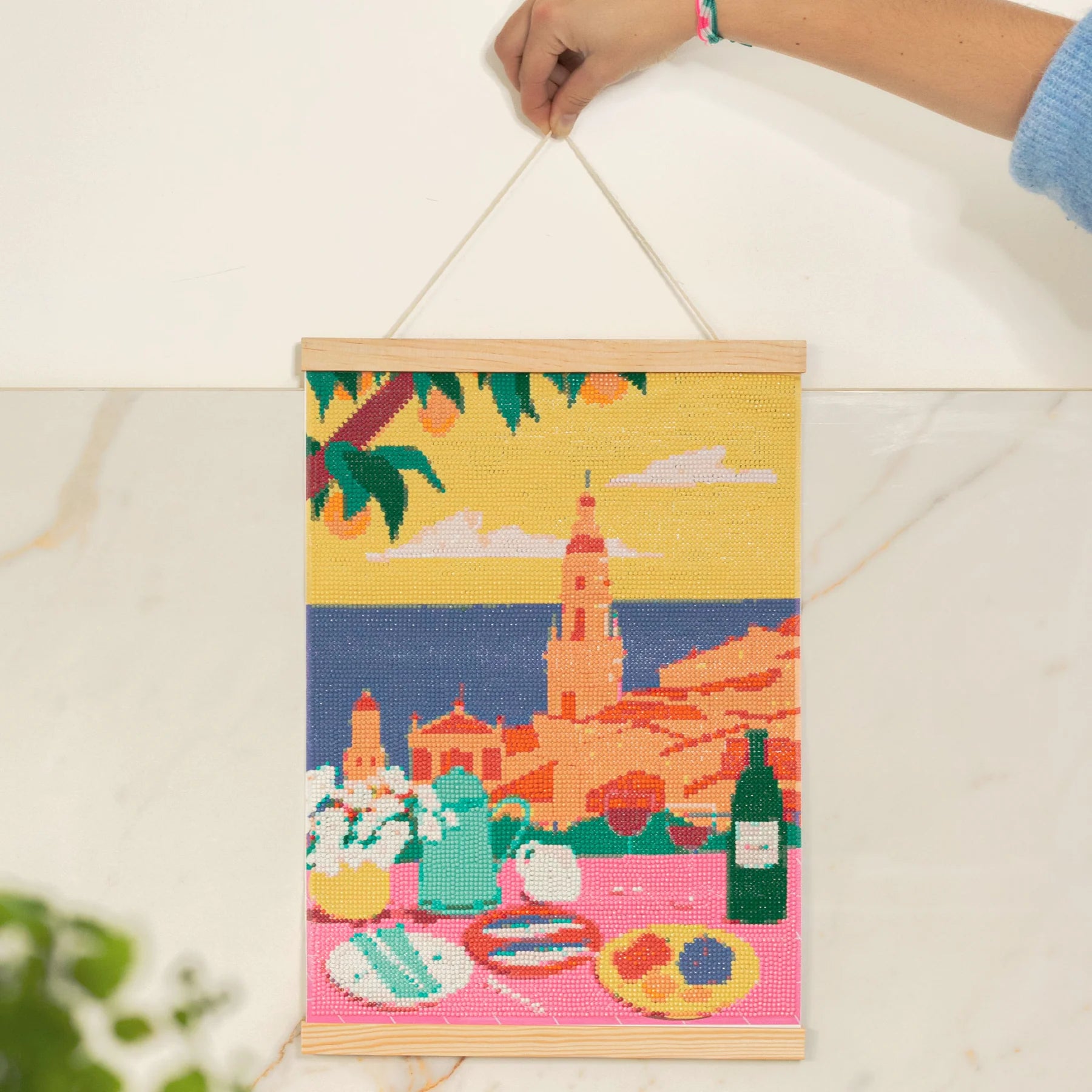 Toile finie Diamond Painting Menton avec strass brillants, encadrée et prête à être exposée.