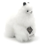 a white stuffed animal is sitting on a bench 