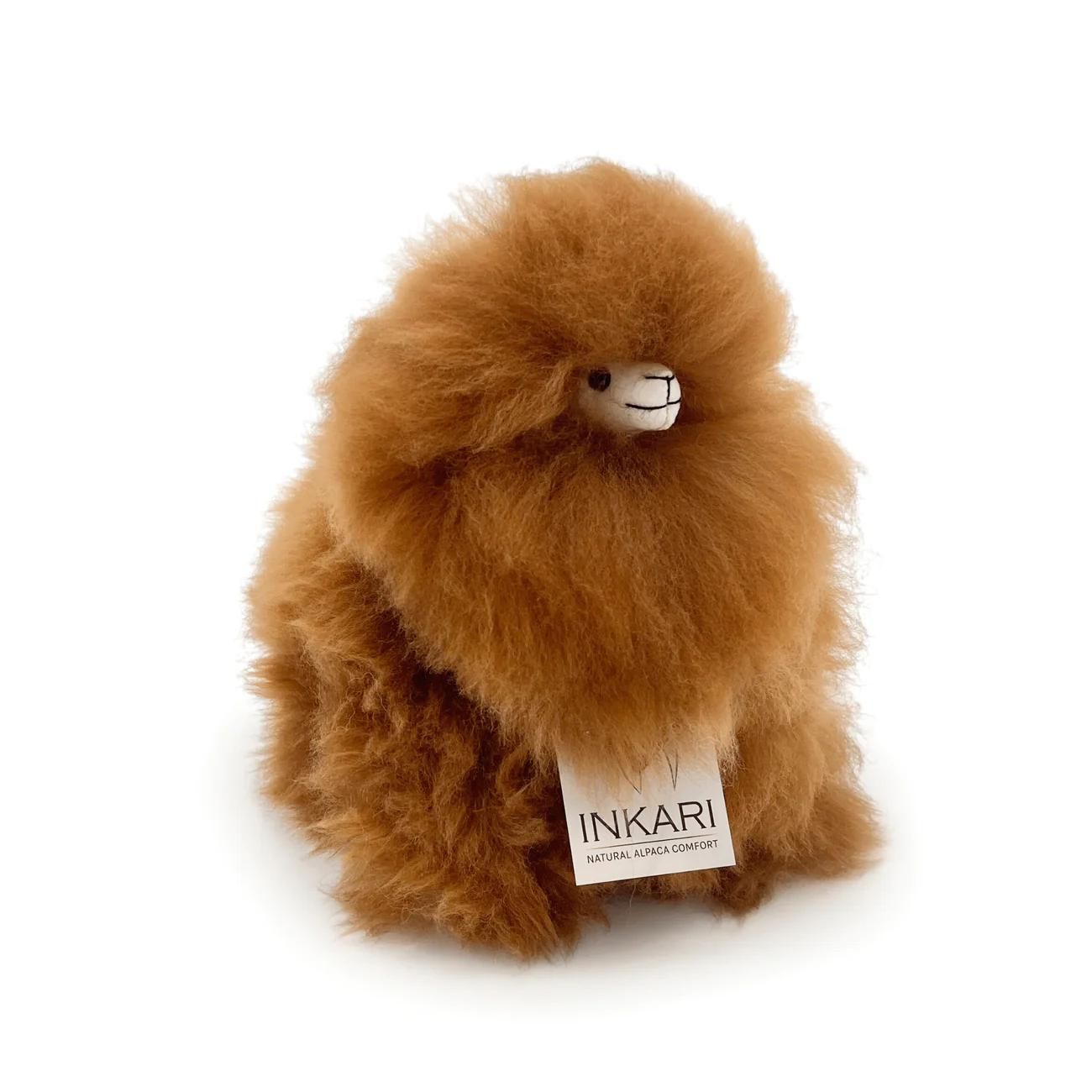 a brown teddy bear sitting on a bench 