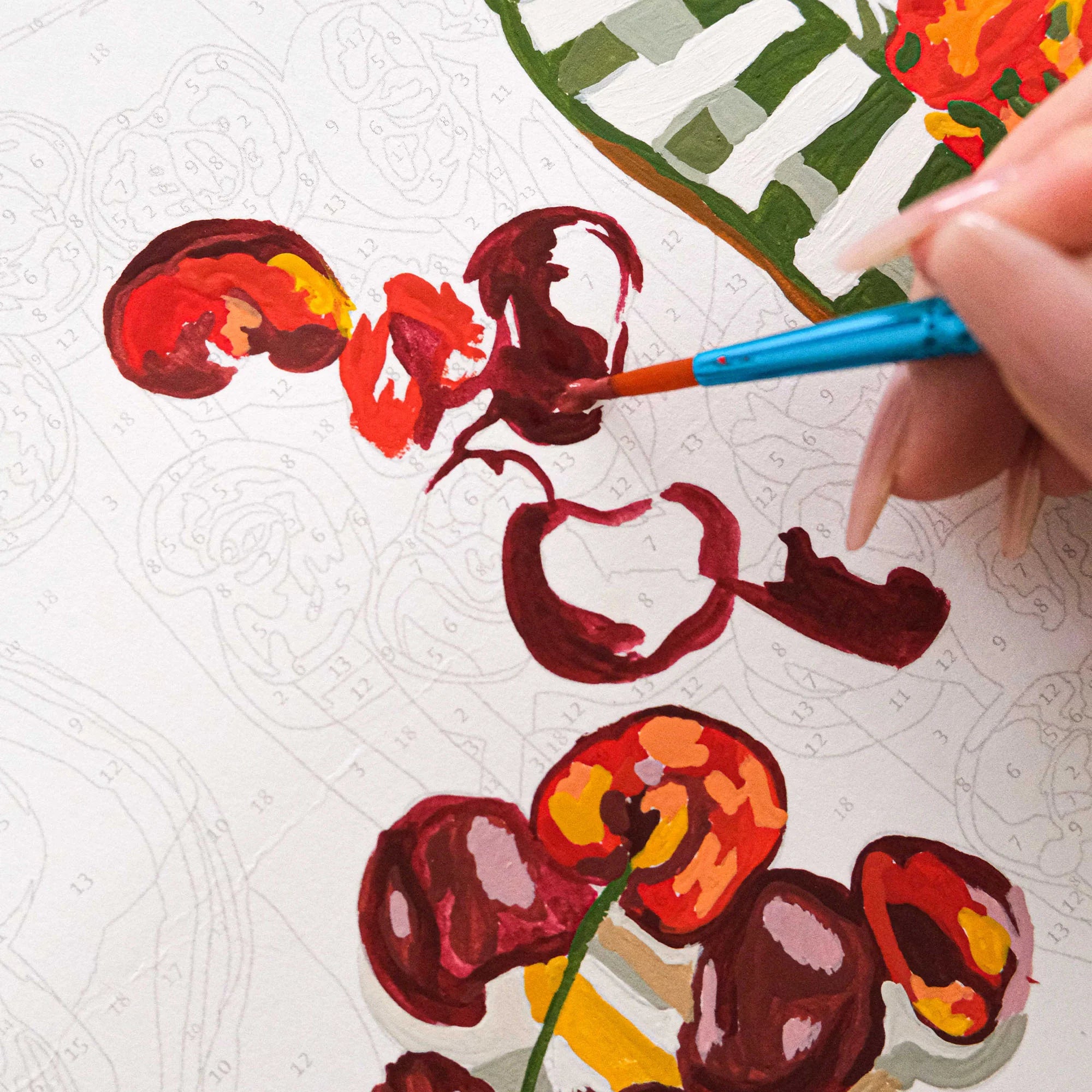 Étape de peinture au numéro – main appliquant des couleurs sur une toile numérotée