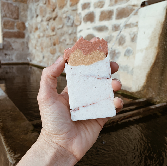 a person holding a half eaten doughnut in their hand 