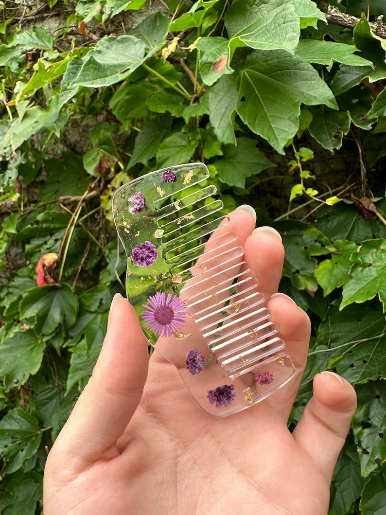 a close up of a person holding a pink flower 